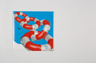 Ein Foto eines quadratischen Drucks mit ineinander verschlungenen roten und weißen Rettungsringen auf blauem Hintergrund, mit den Buchstaben A, D, H und D darauf; ein kleiner Vogel fliegt in der Nähe.