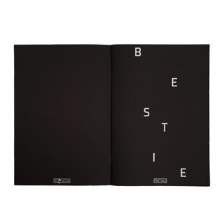 Ein aufgeschlagenes schwarzes Heft mit den Buchstaben „B E S T I E“, die auf der rechten Seite vertikal und diagonal in Weiß angeordnet sind; beide Seiten haben unten ein kleines weißes Etikett.