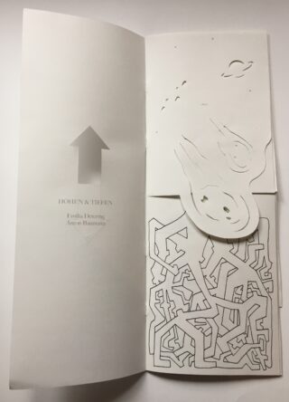 Ein aufgeschlagenes Heft mit dem Titel „Höhen & Tiefen“ zeigt auf der oberen Seite einen nach oben gerichteten Pfeil, ausgeschnittene Formen und auf der unteren Seite ein abstraktes schwarz-weißes, labyrinthartiges Design.