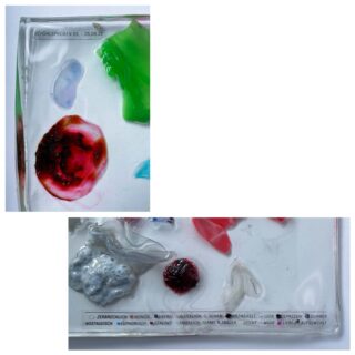 Zwei Nahaufnahmen einer durchsichtigen Kunststoffoberfläche mit bunten Farbflecken und aufgedruckten Etiketten in deutscher Sprache, auf denen Daten und beschreibende Wörter aufgeführt sind.