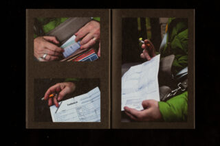 Eine Person in einer grünen Jacke hält ein Formular in der Hand und füllt es mit einem Bleistift aus, während sie in einem Auto sitzt und einen Sicherheitsgurt angelegt hat.