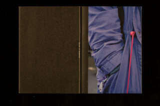 Ein Buchcover mit einem Nahaufnahmefoto einer Person, die eine blaue Jacke mit rosa Kordelzug trägt, neben einem schlichten schwarzen Abschnitt mit vertikalem weißem Text.