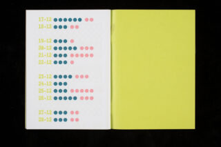 In einem offenen Notizbuch werden Daten auf der linken Seite durch Reihen farbiger Punkte neben jedem Datum angezeigt; die rechte Seite ist durchgehend gelb.