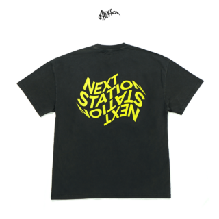 Ein schwarzes T-Shirt mit fettem, verzerrtem gelbem Text „NEXT STATION“ auf der Rückseite.