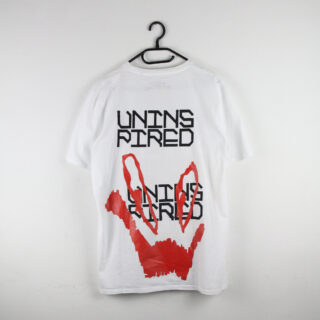 Ein weißes T-Shirt auf einem Kleiderbügel mit dem Wort „UNINSPIRED“ in zweifacher Ausführung in Schwarz und Rot und einem abstrakten roten Grafikdesign unter dem Text.