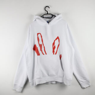 Weißer Hoodie mit Fronttasche und einer großen roten Grafik, die an Hasenohren erinnert. Der Hoodie hängt auf einem Kleiderbügel vor einer weißen Wand.
