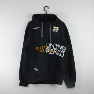 Ein schwarzer Kapuzenpullover mit einer Vordertasche, verschiedenen aufgedruckten Texten und Logos in Weiß und Gelb, der an einem Haken an einer weißen Wand hängt.