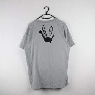 Ein hellgraues T-Shirt auf einem Kleiderbügel mit einem schwarzen, abstrakten Grafikdesign, das einer Hand ähnelt, die ein Friedenszeichen macht, auf dem oberen Rücken aufgedruckt.