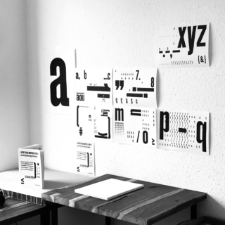 Mehrere Blätter mit schwarzen Buchstaben und Symbolen.