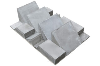 Eine geometrische Anordnung aus grauen Betonblöcken und -platten unterschiedlicher Größe, die in verschiedenen Winkeln auf einer flachen Basis gestapelt und positioniert sind.