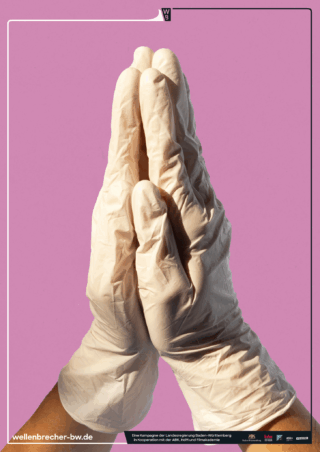 Vor einem schlichten rosa Hintergrund sind zwei Hände mit weißen Latexhandschuhen in einer Geste zusammengepresst, die einem Gebet ähnelt.