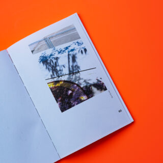 Ein offenes Buch auf orangefarbenem Untergrund zeigt auf der rechten Seite abstrakte Schwarzweiß- und Farbbilder, in der unteren Ecke ist die Zahl 03 aufgedruckt.