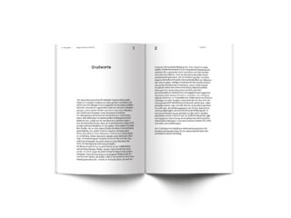 Ein offenes Buch auf weißem Hintergrund mit zwei Seiten deutschem Text, mit der Überschrift „Grußworte“ auf der linken Seite.