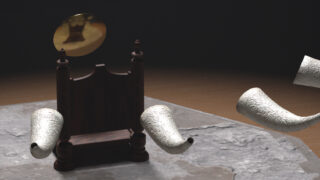 Ein Holzstuhl mit einer runden goldenen Scheibe darüber ist von vier schwebenden, strukturierten weißen Hörnern auf einer rauen Steinoberfläche umgeben.