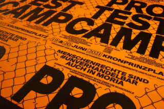 Orangefarbene Plakate mit fettem, schwarzem deutschen Text kündigen ein Protestcamp für Menschenrechte und Flüchtlinge am Kronprinzenplatz vom 20. Juni 2021 an. Die Grafik eines Maschendrahtzauns überlagert das Design.