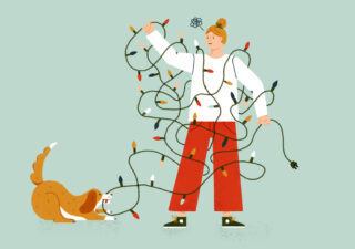 Eine Person hat sich in einer Lichterkette verheddert, während ein Hund spielerisch mit seinem Maul an den Lichtern zieht.