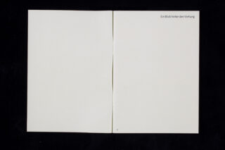 Ein offenes Buch mit leeren Seiten; auf der rechten Seite steht oben rechts der deutsche Satz „Ein Blick hinter den Vorhang“ und unten die Zahl 1.