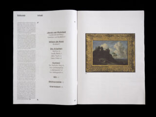 Eine aufgeschlagene Zeitschrift zeigt auf der linken Seite ein Inhaltsverzeichnis und auf der rechten Seite vor schwarzem Hintergrund ein gerahmtes Landschaftsgemäldefoto.