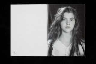 Aufgeschlagenes Buch mit einer leeren linken Seite mit der Aufschrift „M.“ und einem Schwarzweißporträt einer jungen Frau mit langen Haaren auf der rechten Seite.