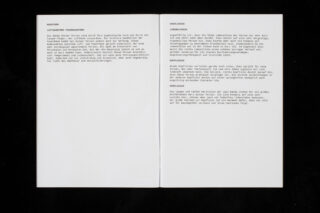 Ein aufgeschlagenes Heft auf schwarzem Untergrund besteht aus zwei Seiten mit Absätzen deutschen Textes in serifenloser Schrift; die linke Seite ist größtenteils leer.