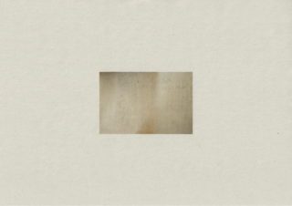 Ein kleiner, verblasster, rechteckiger Fleck aus gealtertem, fleckigem Papier ist auf einem größeren, cremefarbenen strukturierten Hintergrund zentriert.