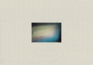 Ein kleines, zentriertes quadratisches Foto zeigt weiches, verschwommenes Licht in Pastellfarben auf einer strukturierten Wand, umgeben von einem schlichten beigen Hintergrund.