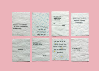 Acht Stücke geprägtes weißes Papier mit verschiedenen Mustern und deutschem Text sind in zwei Reihen auf einem einfarbigen rosa Hintergrund angeordnet.