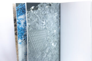 Ein offenes Buch mit Nahaufnahmen von kristallinen und strukturierten Oberflächen, mit einer leeren Seite auf der rechten Seite.