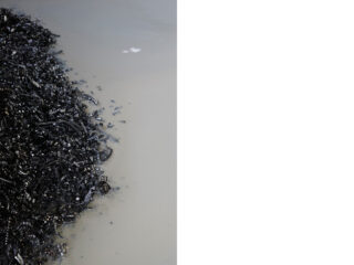 Auf der linken Seite des Bildes befindet sich ein Haufen Metallspäne, umgeben von einer Lache heller Flüssigkeit, mit einem sauberen weißen Hintergrund auf der rechten Seite.