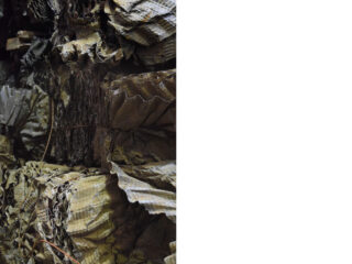 Nahaufnahme der übereinander geschichteten, zerknüllten Pappbögen auf der linken Seite des Bildes, mit einem schlichten weißen Hintergrund auf der rechten Seite.