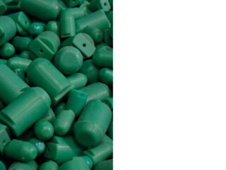 Links ein Stapel zylindrischer und runder Kappen aus grünem Kunststoff, rechts ein leerer weißer Bereich.