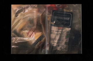 Eine Plastiktüte mit verschiedenen verpackten Lebensmitteln, darunter ein Produkt mit dem Label Brunenhof, fotografiert vor einem dunklen Hintergrund.