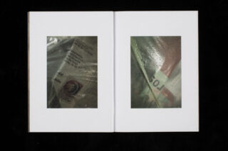Ein offenes Buch zeigt zwei Seiten, jede mit einem zentrierten Foto, das gedruckte Materialien zeigt, die mit zerknittertem, halbtransparentem Kunststoff überzogen sind.