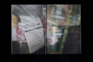 Eine Nahaufnahme von Lebensmitteln in einer Plastiktüte, einschließlich eines ausgedruckten Kassenbons und verpackter Lebensmittel, die teilweise durch die durchsichtige Tüte sichtbar sind.