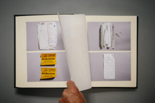 Eine Hand blättert durch ein Fotoalbum, in dem seitenweise Bilder von Quittungen, Eintrittskarten und Papierbelegen angezeigt werden.