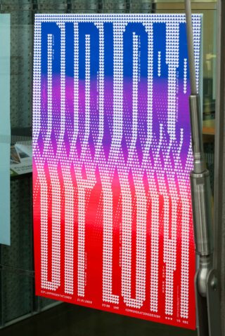 Ein farbenfrohes Poster mit den Worten „DIPLOM OUT LOUD“ in einer fetten, pixeligen Schriftart auf einem Hintergrund mit Farbverlauf in Lila, Rosa und Rot, teilweise verdeckt durch eine Glastür.
