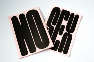 Zwei rosa Zeitschriften mit großen, fetten, schwarzen Buchstaben, die auf der einen „NO“ und auf der anderen „SEX“ buchstabieren, überlappend auf einer weißen Oberfläche.