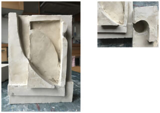 Eine geometrische Gipsskulptur mit sich kreuzenden gebogenen und rechteckigen Formen, detailliert aus zwei Winkeln auf einem Tisch in einer Werkstattumgebung gezeigt.