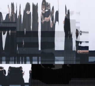 Personen spiegeln sich in einer unregelmäßigen Glaswand.