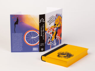 Gezeigt wird ein Buch mit schwarzem Rücken und gelbem Einband, auf dem die Illustration eines Hundes zu sehen ist, sowie ein bunter Schutzumschlag, auf dem ein Hund auf einem Fahrrad abgebildet ist.