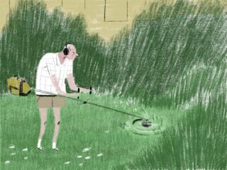 Eine Person mit Kopfhörern schneidet mit einem Fadentrimmer Gras in einem Hinterhof, der von hohen Büschen und einem Zaun umgeben ist.