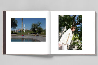Ein aufgeschlagenes Fotobuch zeigt auf der linken Seite eine Teichszene mit Menschen und Hunden und auf der rechten Seite eine Frau im weißen Outfit, die im Freien steht.