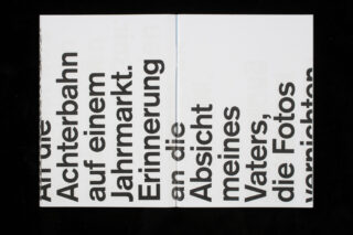 Ein offenes Buch zeigt fettgedruckten schwarzen deutschen Text auf beiden Seiten, wobei die übergroßen Buchstaben an den Rändern teilweise abgeschnitten sind. Der Hintergrund ist weiß.