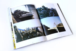 Ein offenes Buch mit vier Fotografien von Industrieszenen, darunter ein Lastkahn mit Altmetall und Schutthaufen mit Baumaschinen.