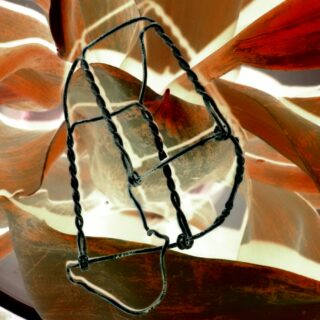 Ein verdrehtes Drahtobjekt wird auf einen abstrakten Hintergrund mit wirbelnden Formen und Schattierungen von Orange, Braun und Creme gelegt.