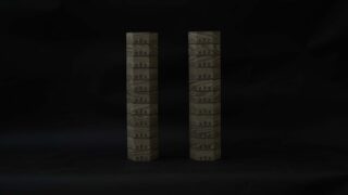 Zwei zylindrische Objekte mit architektonischen Mustern stehen aufrecht nebeneinander vor einem schlichten schwarzen Hintergrund.