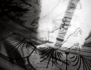 Schwarzweißfoto, das abstrakte Schatten und Umrisse über einer dekorativen Oberfläche mit komplizierten Mustern und geschwungenen Linien zeigt.