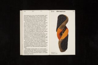 Ein aufgeschlagenes Buch zeigt auf der linken Seite einen deutschen Text zum Thema „Minimalschuhe“ und auf der rechten Seite das Bild eines orangefarbenen Minimalistschuhs mit schwarzer Sohle.