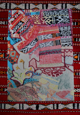 Ein Textilkunstwerk mit komplizierten geometrischen und gemusterten Designs in verschiedenen Farben, eingefasst von einem roten Webstoff mit horizontalen Zierstreifen.