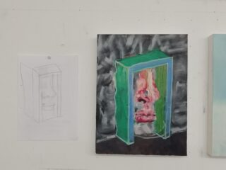 Eine Bleistiftskizze und ein gemaltes Kunstwerk einer Nase und eines Mundes in einem grünen rechteckigen Rahmen werden nebeneinander auf einer weißen Wand angezeigt.